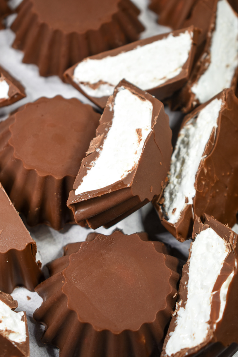 Sliced chocolate marshmallow cups on a white surface