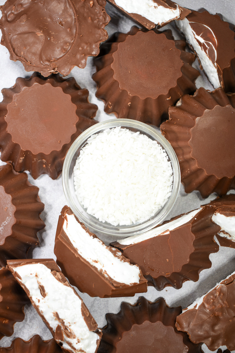 Bowl of coconut surrounded by fluted milk chocolate cups