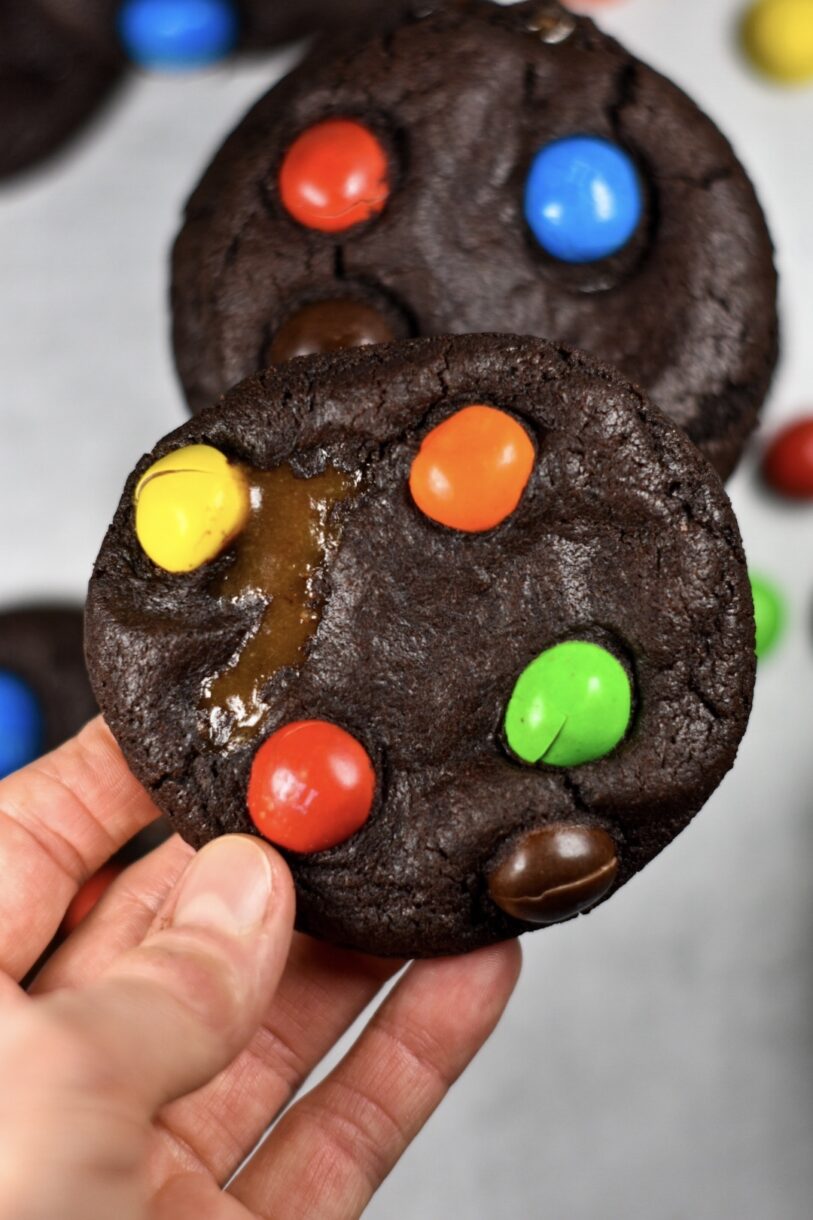 Hand holding a chocolate M&M cookie