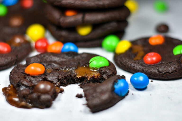 Caramel M&M Cookies and M&M candies on a white surface