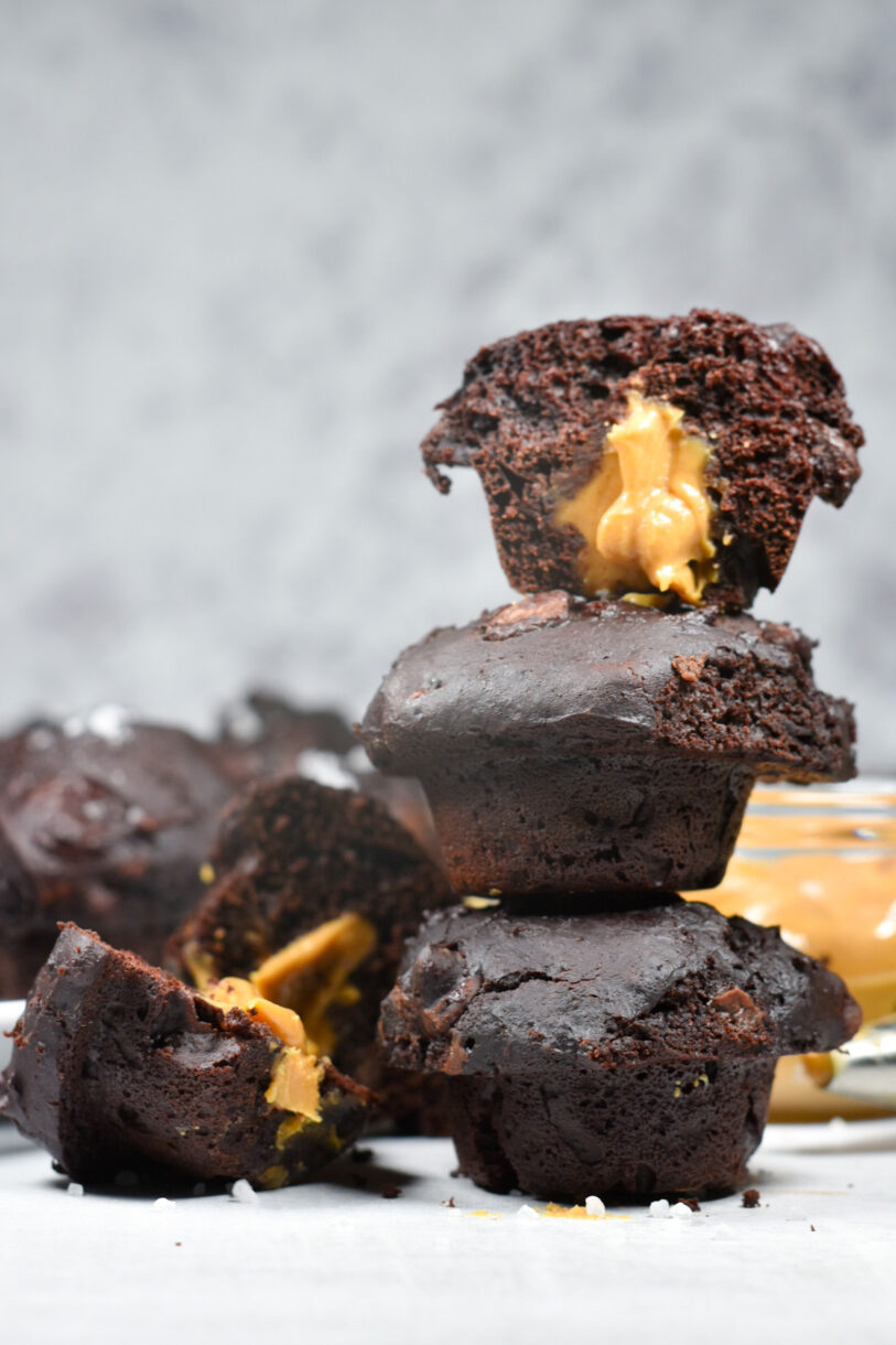 Stack of peanut butter filled chocolate muffins with a light grey background