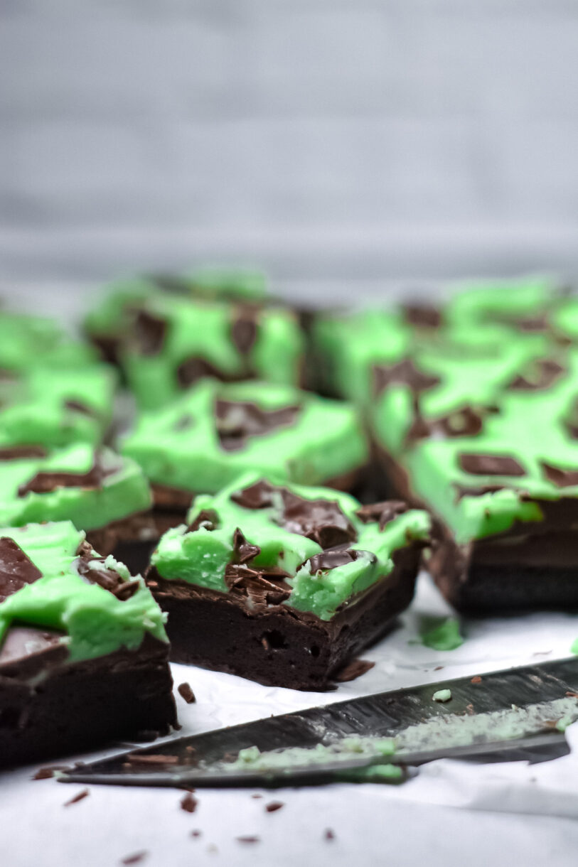 Chocolate mint brownies and a knife on a white surface