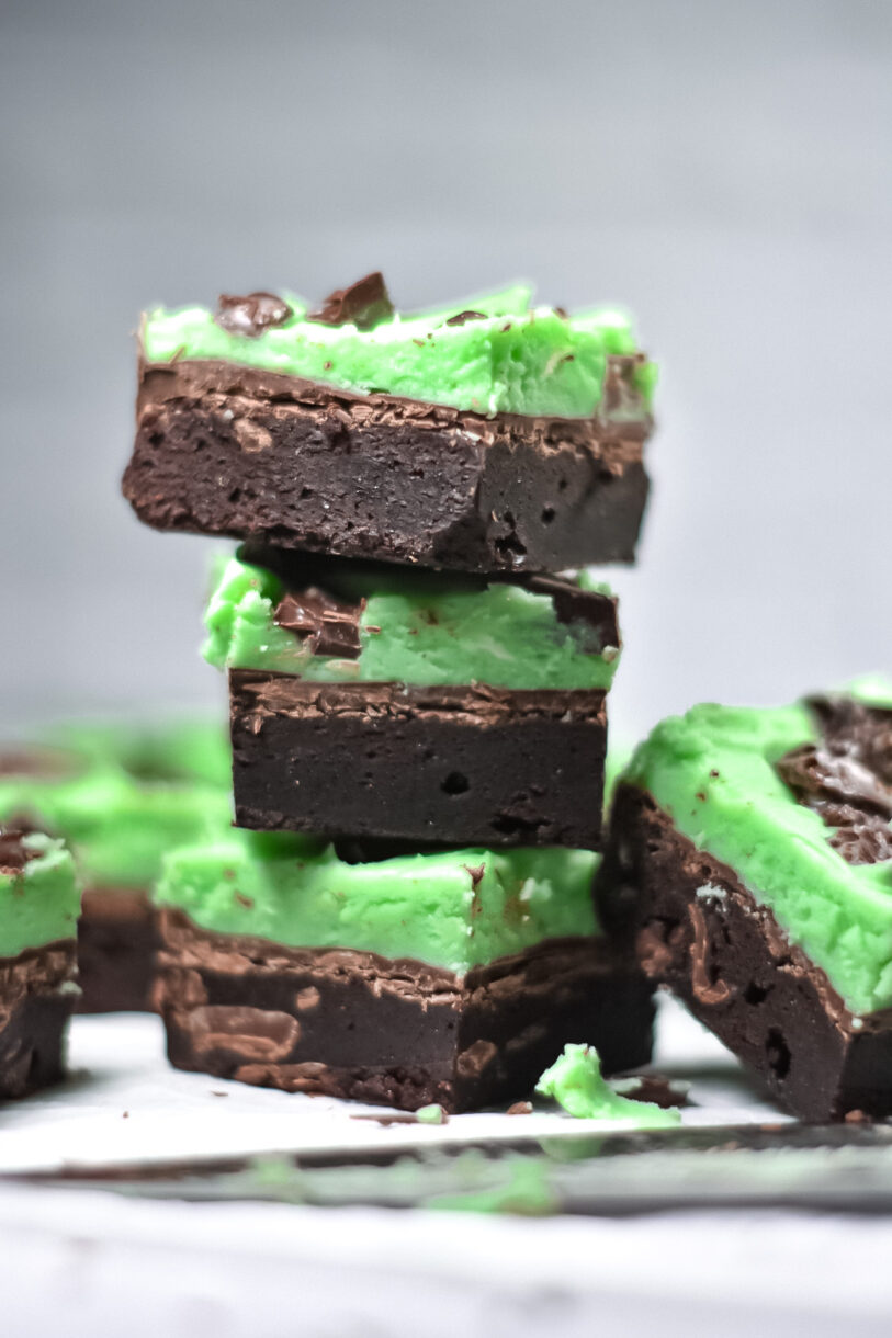A stack of three chocolate mint brownies with peppermint frosting