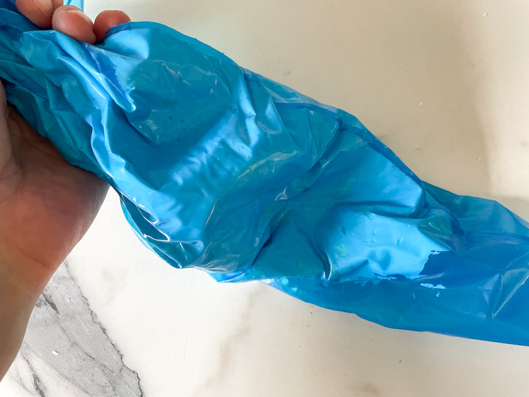 Hand holding a blue piping bag