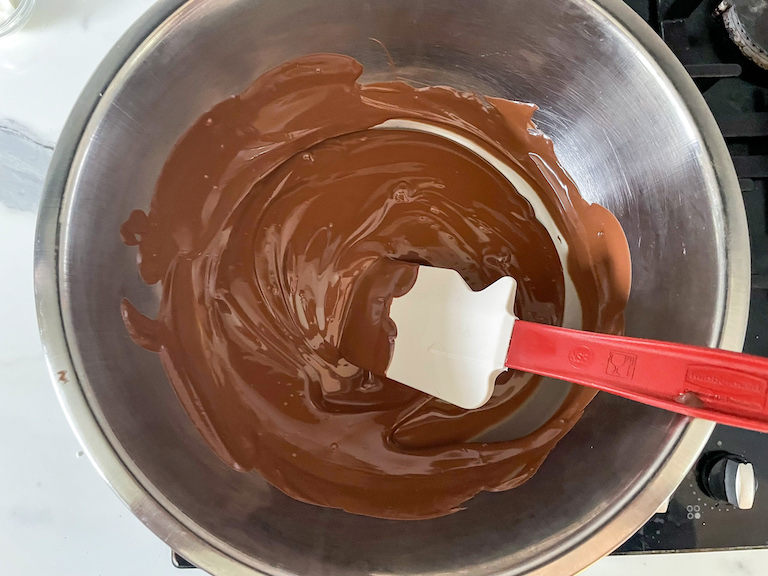 Bowl of melted milk chocolate with spatula