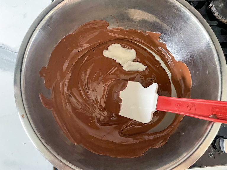 Adding coconut oil to melted chocolate