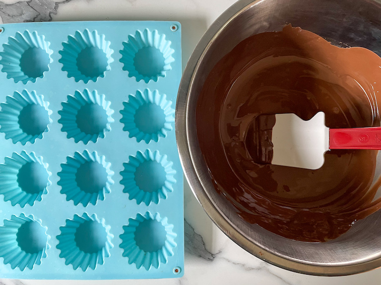 A silicone mould and a bowl of melted chocolate