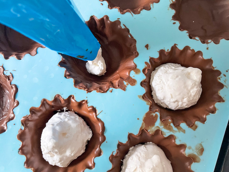 Piping marshmallow into chocolate cups