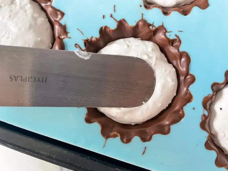 Palette knife spreading marshmallow into mallo cup