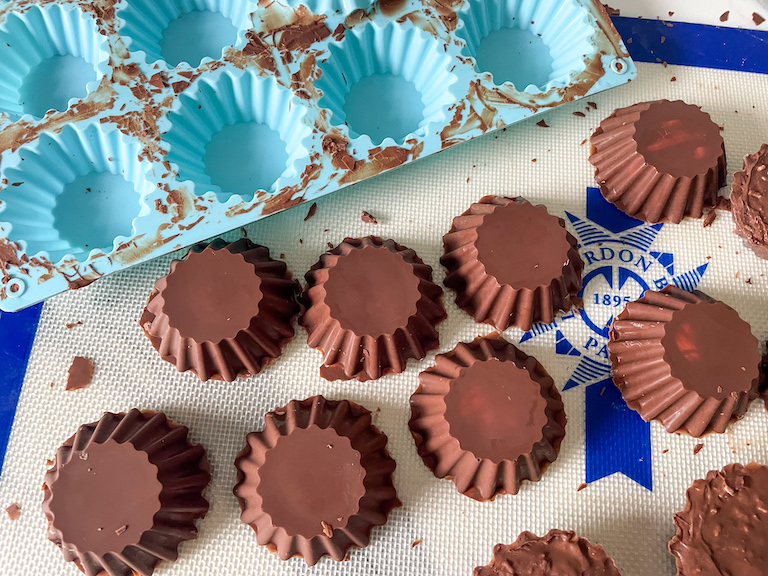 Popping finished chocolate cups onto a silicone mat