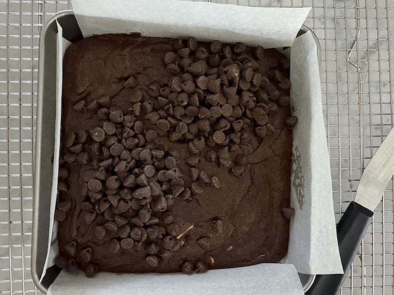 chocolate chips scattered over a pan of brownies