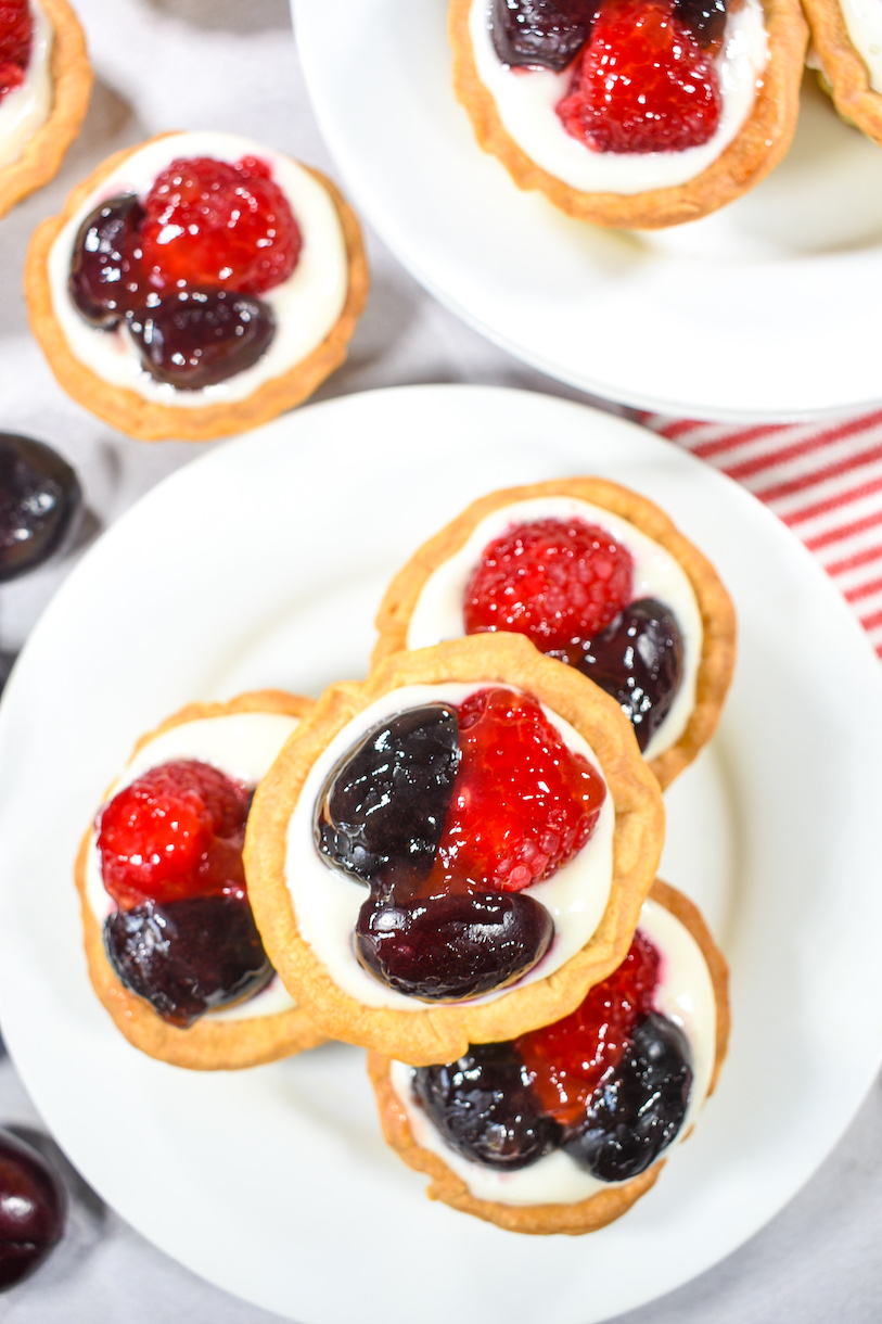 berry cherry tartlets arranged on a white plate