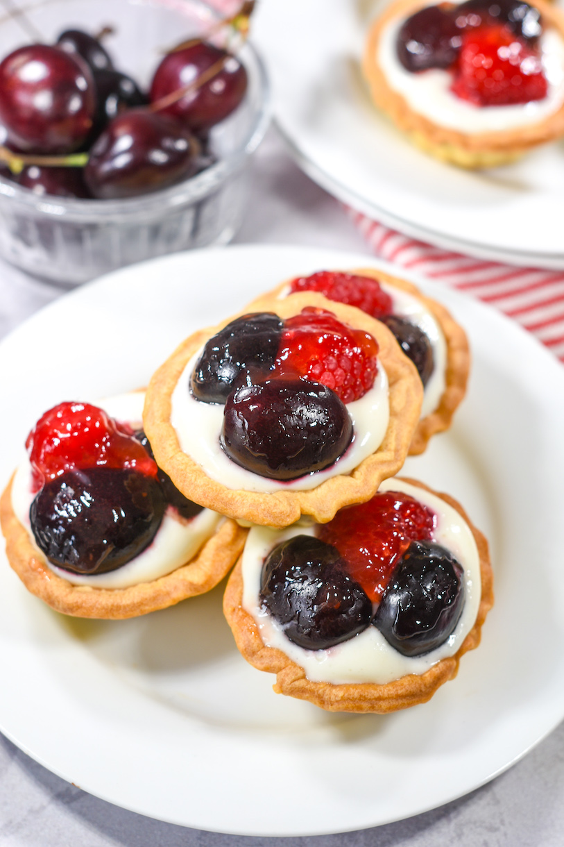 Miniature berry tarts on a white plate
