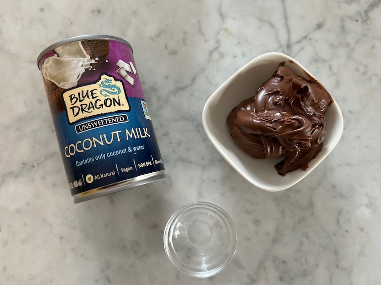 A can of coconut milk, dish of nutella, and dish of alcohol