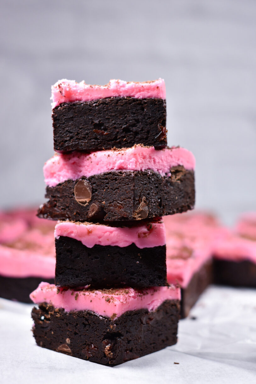 a stack of cherry buttercream brownies against a white background