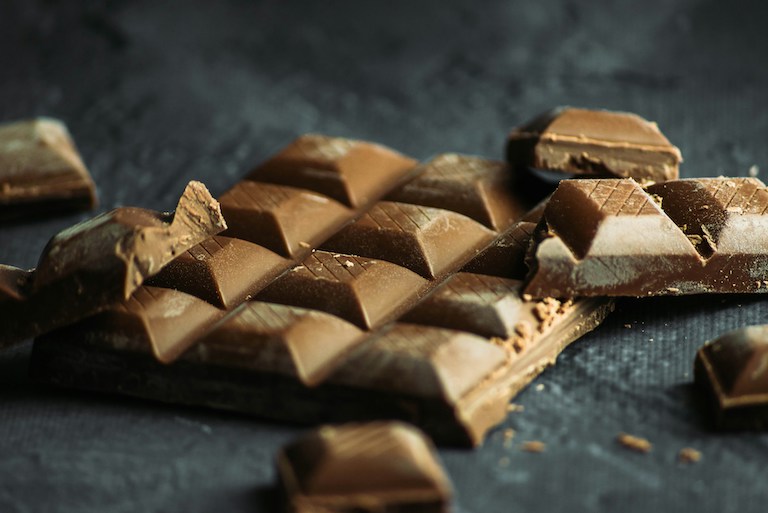 broken pieces of chocolate bar on a dark surface