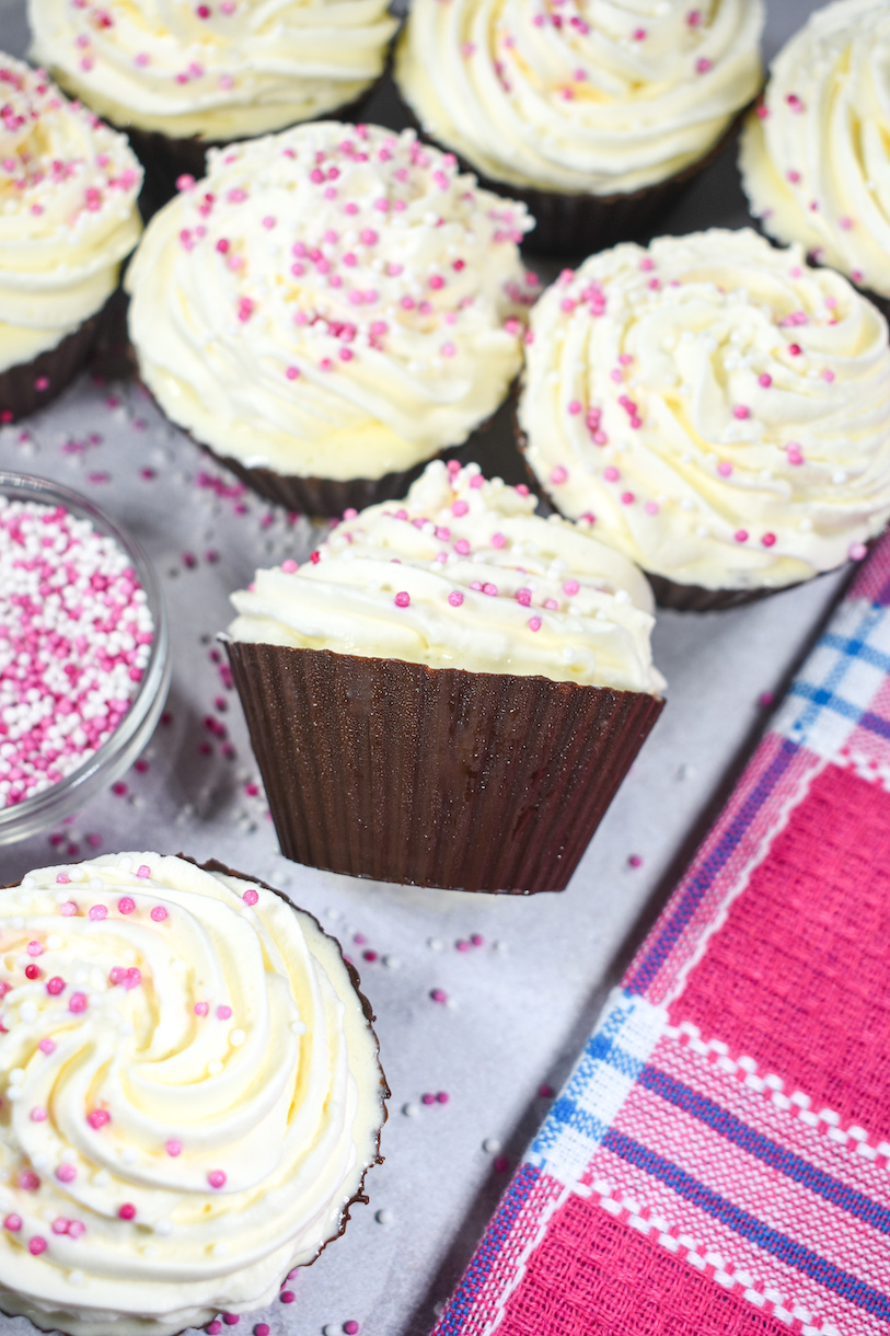 ice cream cupcakes and a pink towel arranged on a white surface