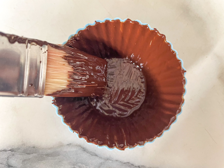 Brushing chocolate into a silicone cupcake liner
