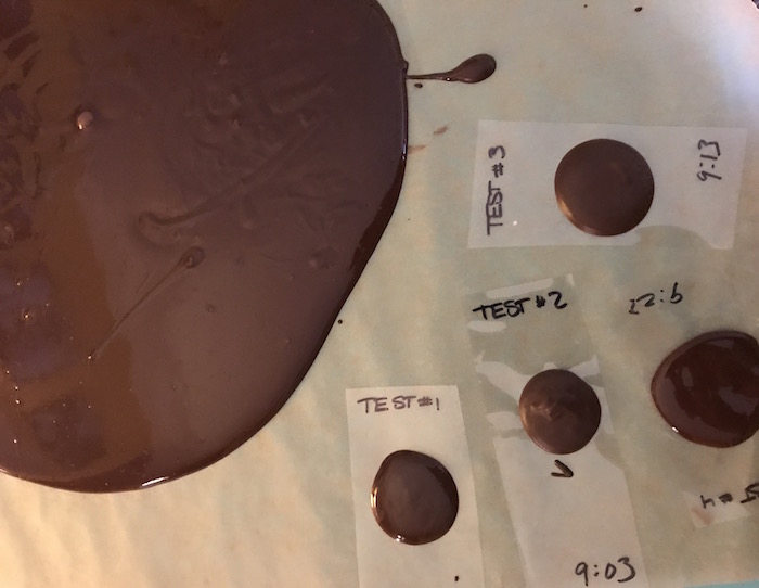 A large pool of chocolate and tempering tests on parchment
