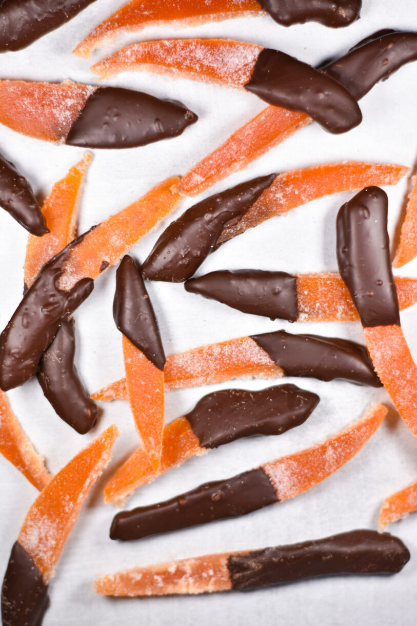 Candied grapefruit peel dipped in chocolate, on white background