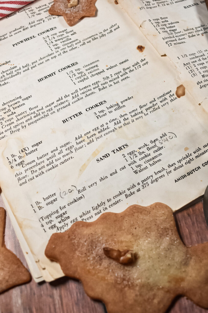 A tattered cookbook page and sand tart Christmas cookies