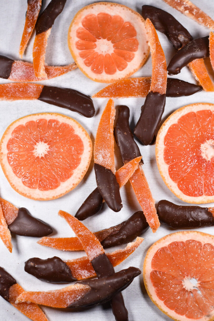 Candied grapefruit peels and slices of grapefruit on a white background