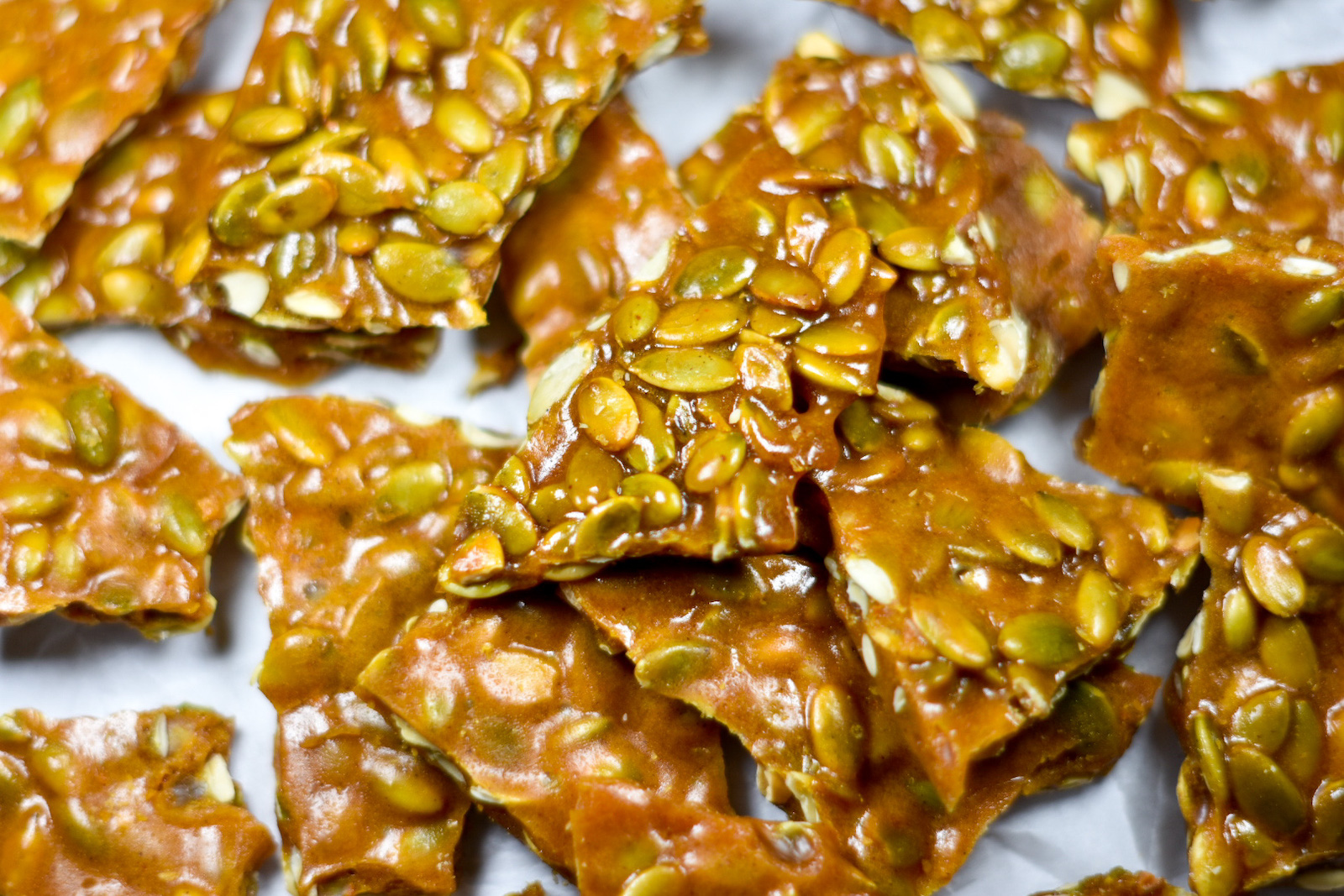 pumpkin seed brittle arranged on a sheet of white parchment