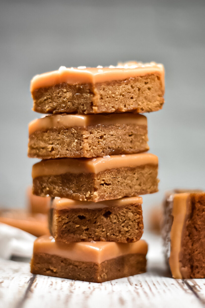 Salted Caramel Blondies in a stack on a white surface