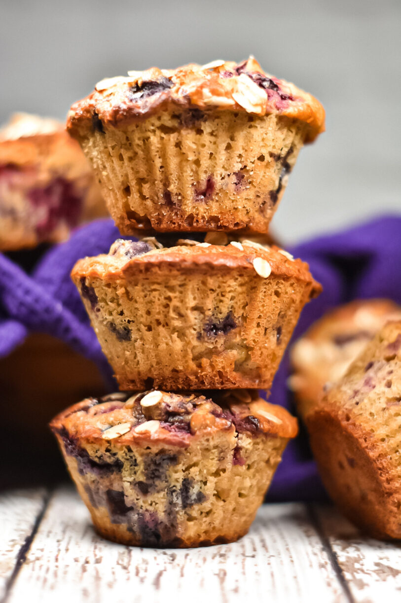 Mixed berry oatmeal cornmeal muffins in a stack of three