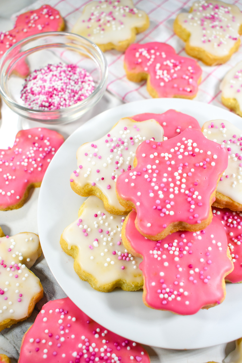 Pink and white frosted animal crackers arranged on a small plate