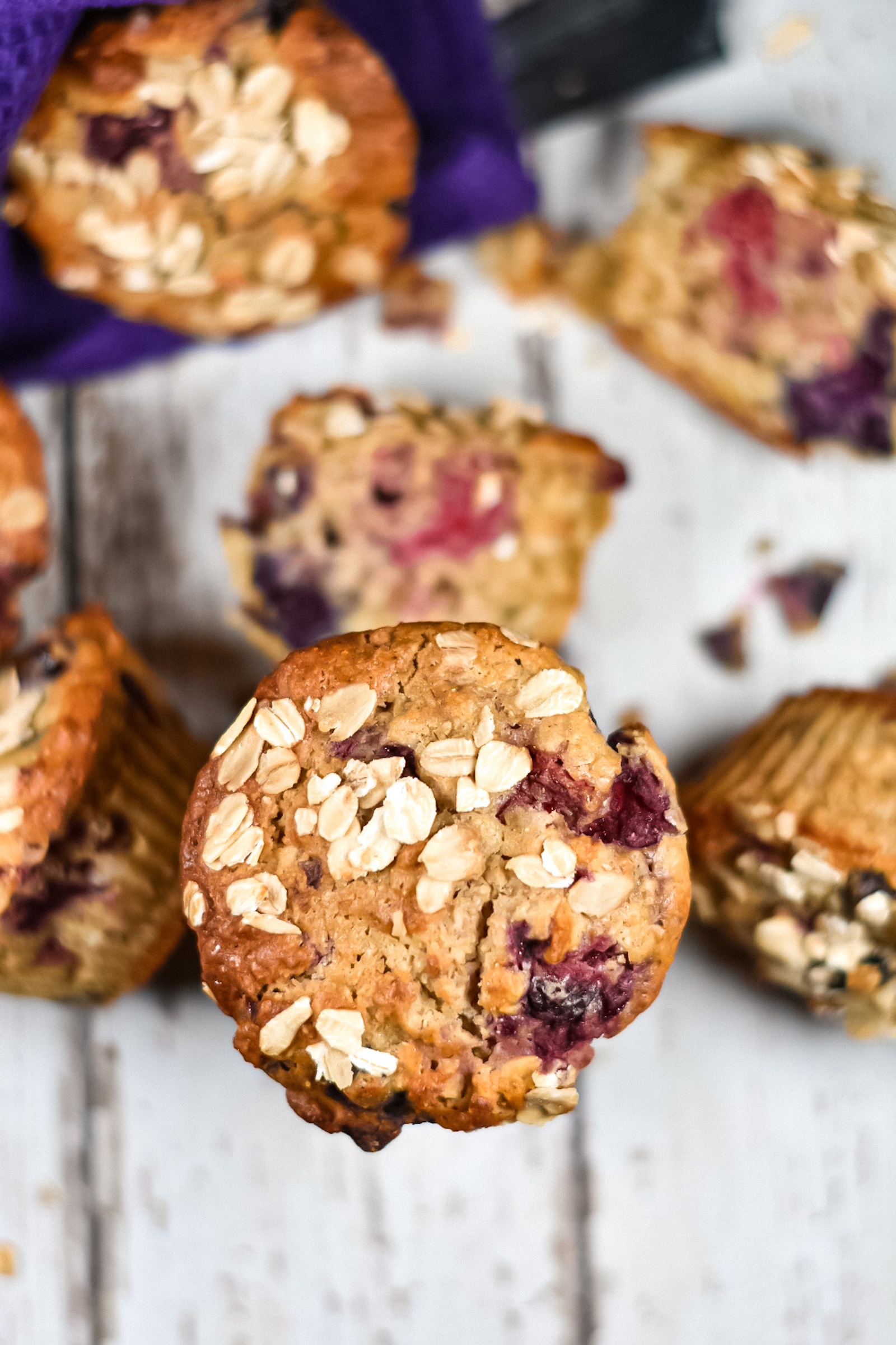 Mixed berry muffins on a white wood surface