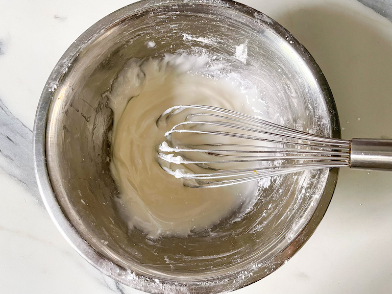 Frosting in a bowl with a whisk