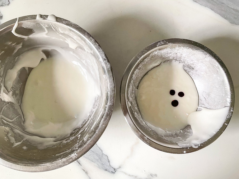 Two metal bowls of white frosting