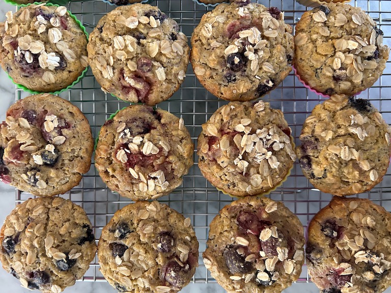 A wire rack with mixed berry muffins