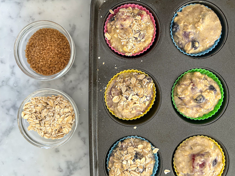 Sprinkling sugar and oats on top of muffins