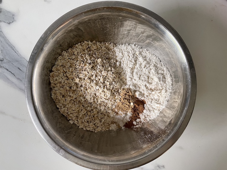 Oats, flour, and spices in a metal bowl