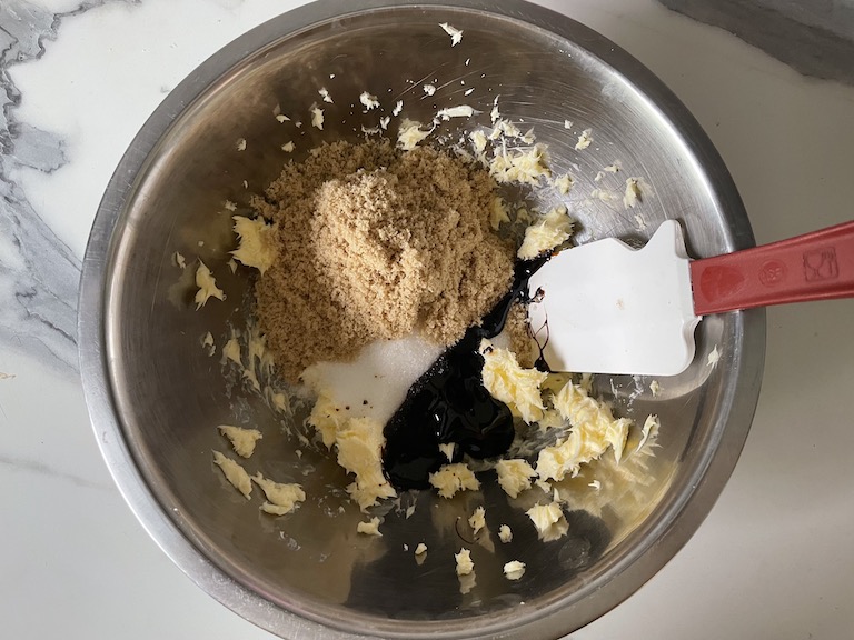 Brown sugar, molasses, and butter in a metal bowl with a spatula