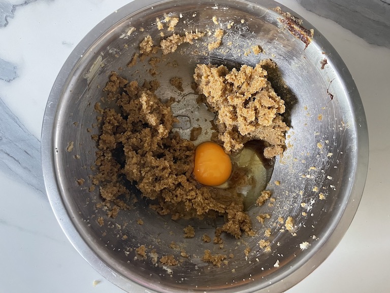 Sugar, butter, and an egg in a metal mixing bowl
