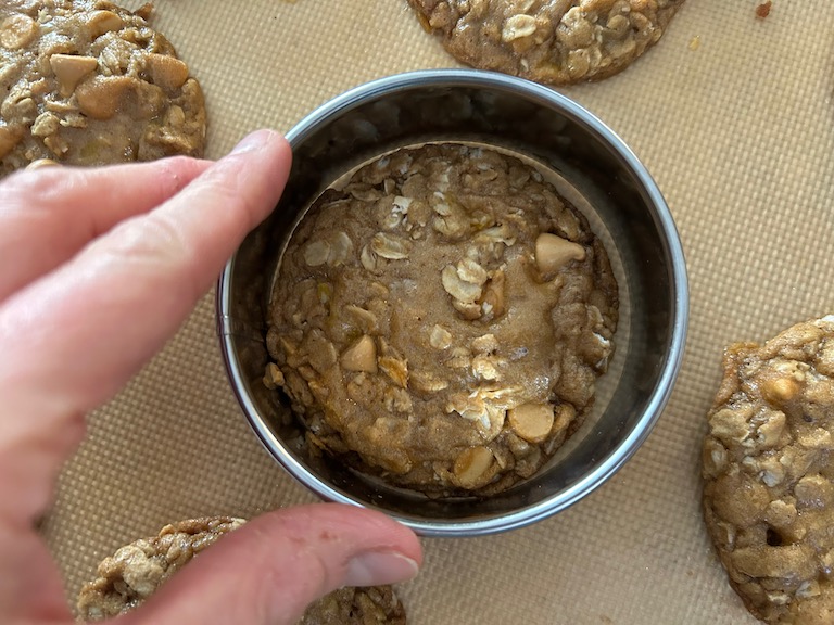 Hand reshaping cookie with a metal cutter