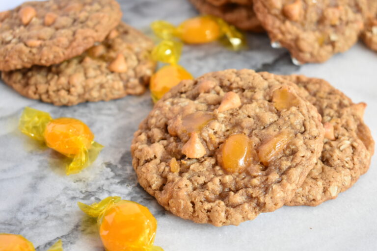 Triple Butterscotch Oatmeal Cookies and hard candies on a marble surface