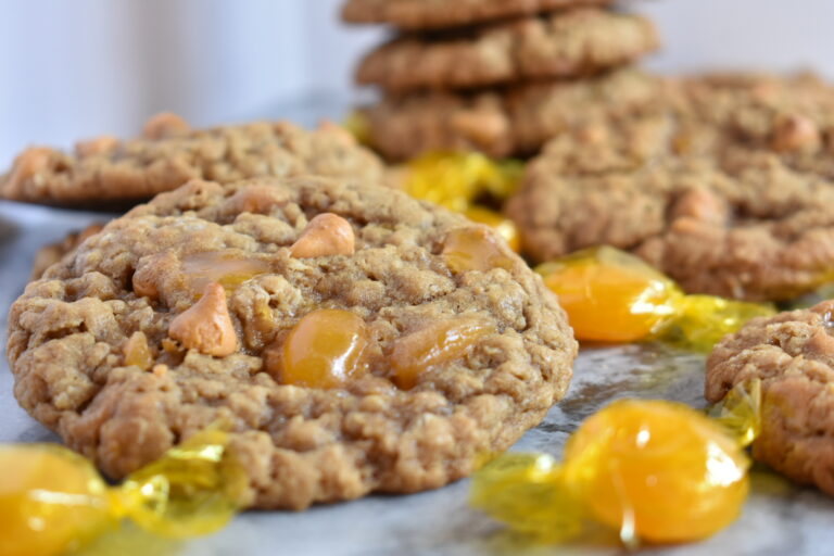 Triple Butterscotch Oatmeal Cookies and hard candies on a marble surface