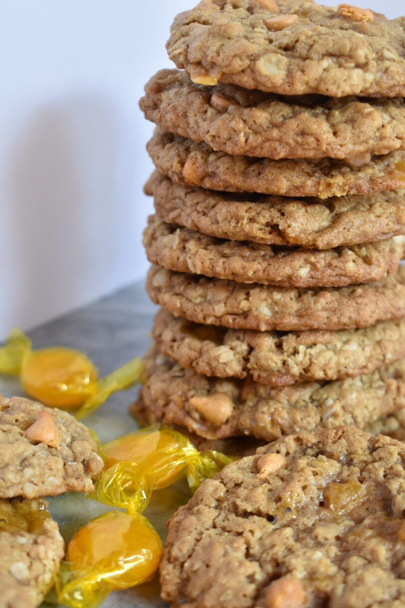 Butterscotch oatmeal cookies and butterscotch hard candy on a white surface
