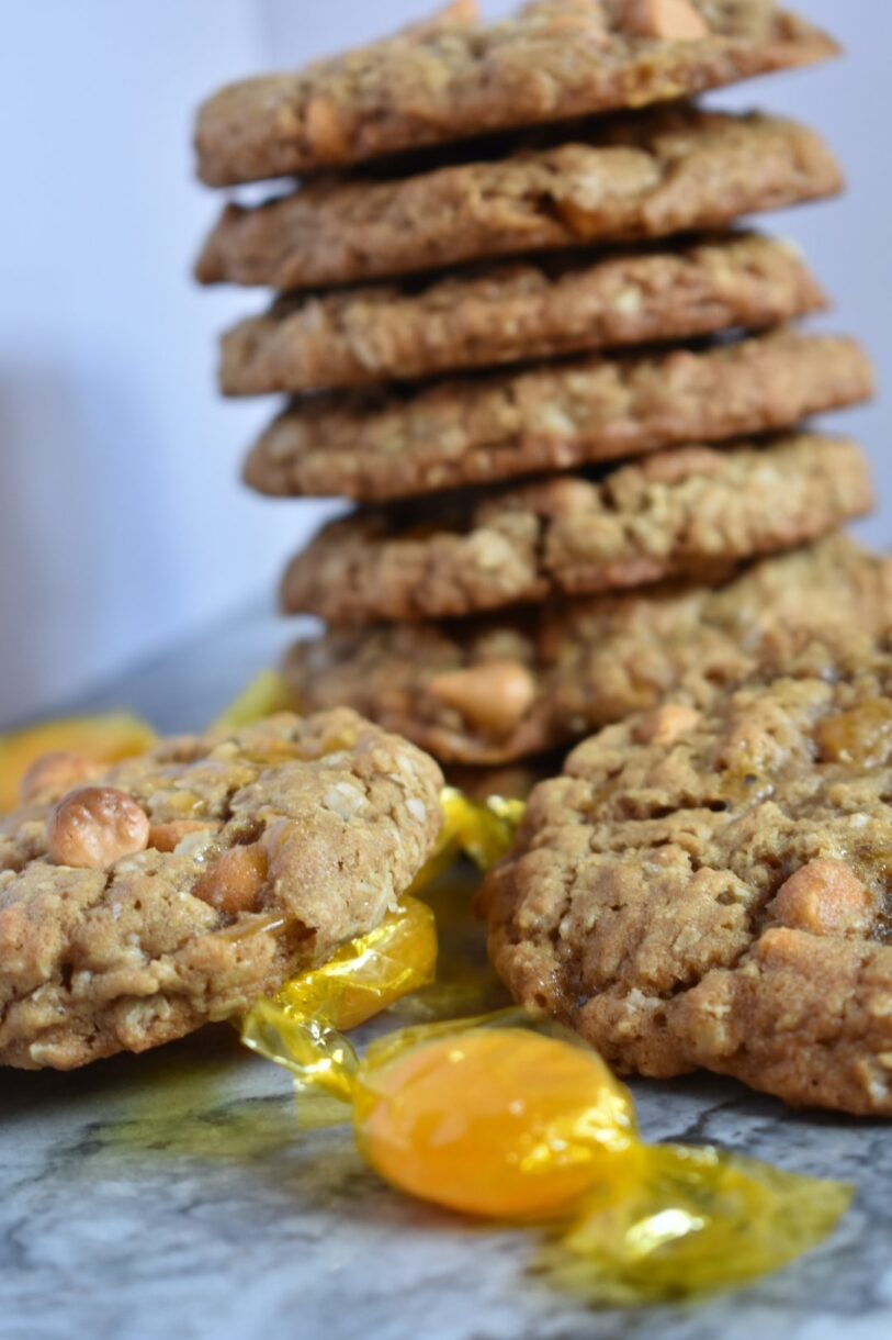 Butterscotch oatmeal cookies and butterscotch hard candy on a white surface