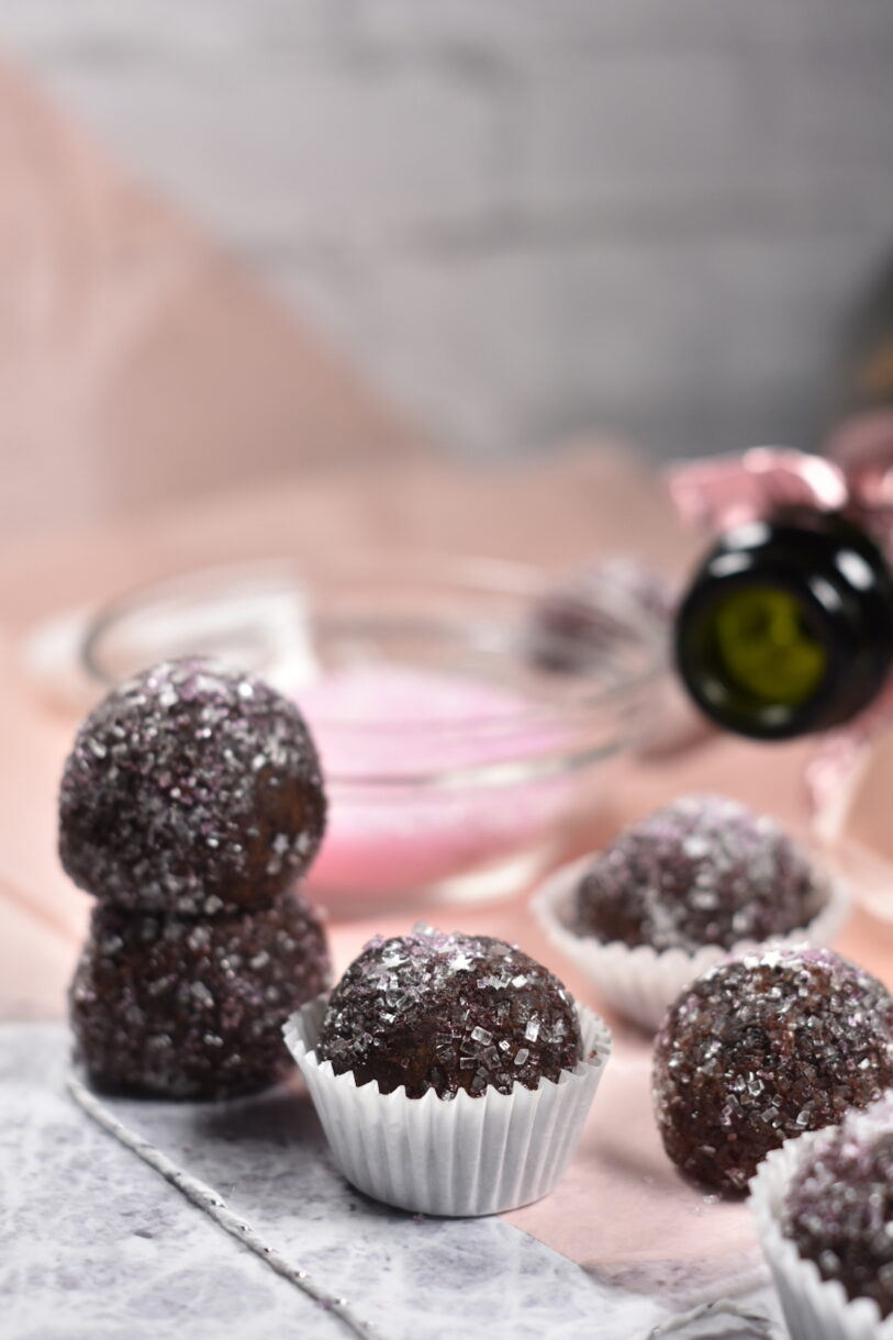 Sparkling Wine Truffles in truffle cups, with pink tissue paper and a bowl of pink sugar