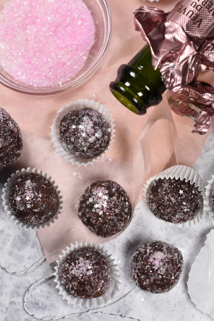 Sparkling Rosé Truffles and a bowl of pink sugar on a sheet of pink tissue paper