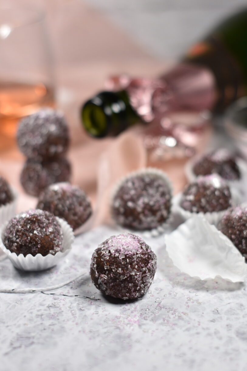 Unwrapped chocolate truffle decorated with pink sugar