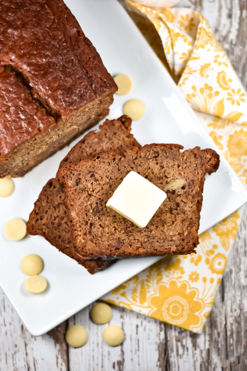 Chai spiced banana bread loaf and slices on a white rectangular plate