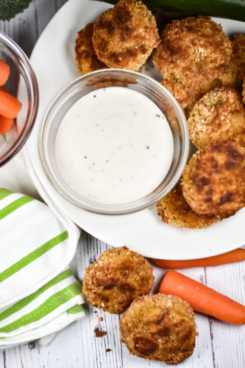 Baked vegetable nuggets on a white plate with ranch dip