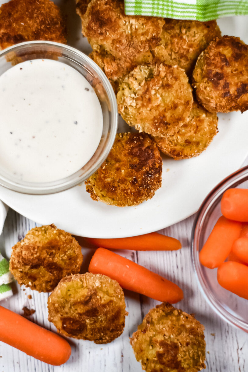 Baked vegetable nuggets on a plate with ranch dip and baby carrots