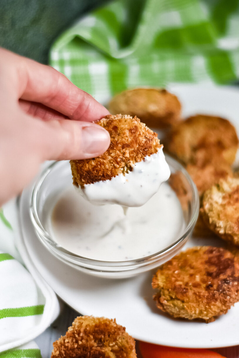Hand dipping a nugget into ranch dressing